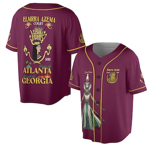Könnte beinhalten: Burgunderfarbenes Baseball-Trikot mit goldfarbenen Zierleisten und Knopfverschluss. Die Vorderseite zeigt eine Grafik einer Figur und den Text "Your Name" und "Elmrra Azema Court 1010". Die Rückseite zeigt "Elmrra Azema Court" und "Atlanta, Desert of Georgia".