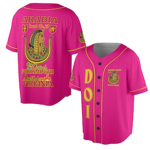 Könnte beinhalten: Ein leuchtend pinkfarbenes Baseball-Trikot mit gelben und schwarzen Akzenten. Auf der Rückseite steht "ARABIA Court No. 23" und ein ägyptisches Motiv. Auf der Vorderseite steht "DOI" und "ARABIA COURT" mit Platz für einen Namen.