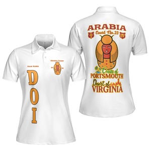 Könnte beinhalten: Weißes Poloshirt mit "DOI" in orangefarbenen Blockbuchstaben. Das Shirt hat "ARABIA COURT" und ein Emblem auf der Vorderseite sowie "ARABIA Court No.23" mit einer ägyptisch inspirierten Grafik auf der Rückseite, zusammen mit "Oasis of Portsmouth Desert of Virginia".