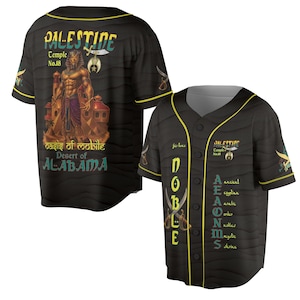 Op de afbeelding: Zwart honkbalshirt met gele rand en knoopsluiting. Het shirt heeft de tekst "PALESTIDE Temple No.18" en een afbeelding van een Egyptische figuur. Extra tekst is "Oasis of Mobile Desert of ALABAMA".