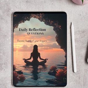 May include: A digital tablet displays a serene scene of a person meditating in water at sunset, with the text "Daily Reflection QUESTIONS" and "Become Aware of your triggers." A white stylus and a small potted plant are next to the tablet.