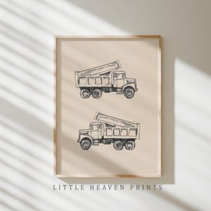 Könnte beinhalten: Ein gerahmter Druck mit zwei schwarz-weißen Illustrationen von Muldenkippern mit angehobenen Mulden. Das Kunstwerk ist vor einem beigefarbenen Hintergrund angeordnet und enthält unten den Text "LITTLE HEAVEN PRINTS".