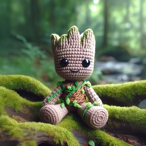 Pode incluir: Boneca de crochê de um personagem com aparência de árvore. A boneca tem um corpo marrom, detalhes verdes e olhos grandes e pretos. Está sentada em um tronco coberto de musgo em um ambiente florestal.