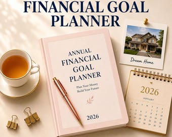 Könnte beinhalten: Ein hellrosa jährlicher Finanzplaner mit dunkelblauem Text, der Annual Financial Goal Planner, Plan Your Money, Build Your Future und 2026 lautet. Ein roségoldener Stift liegt auf dem Einband neben einem 2026 Kalender, einem Foto und einer Tasse.