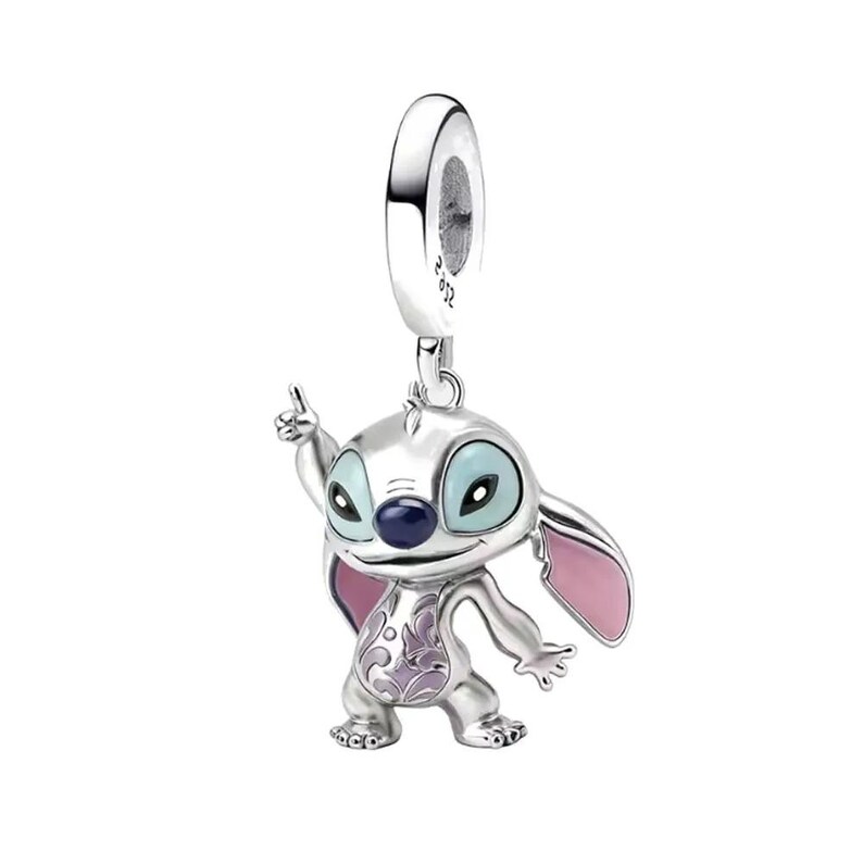 May include: A silver charm featuring the character Stitch from the Disney movie Lilo & Stitch. The charm has blue eyes, a dark blue nose, and pink ears. It is detailed with a purple floral design on its body and is pointing with its right hand.