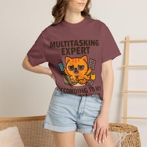 Camiseta "Experto en multitarea según mi CV" | Camiseta divertida con un gato estresado y un portátil, humor laboral.