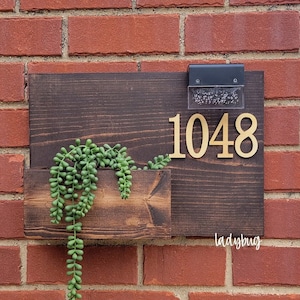 Rustiek adresbord met plantenbak. Houten adresbordje. Adrespaneel. Houten huisbord. Adresvak.