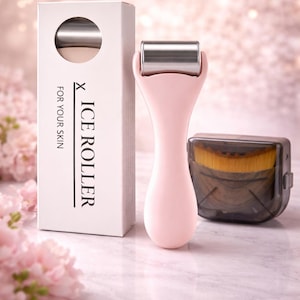 Op de afbeelding: Een roze ijsroller met een zilveren kop en een witte doos met de tekst "X ICE ROLLER FOR YOUR SKIN". Naast de roller staat een doorzichtige, donkere container met een borstel. De achtergrond is zachtroze.