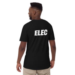 May include: Black short-sleeved t-shirt with the word "ELEC" printed in bold white letters on the back. The shirt is made of a soft material and is worn by a person.