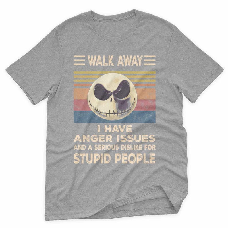 May include: Gray t-shirt featuring a graphic of a skull with the text "WALK AWAY" above and "I HAVE ANGER ISSUES AND A SERIOUS DISLIKE FOR STUPID PEOPLE" below. The skull has a black and white design with a smiling mouth.