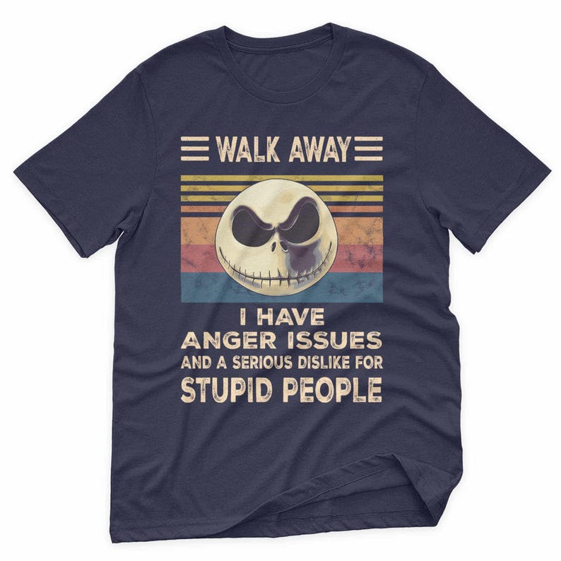 May include: Navy blue t-shirt with a graphic of a skull with a sinister expression. The text reads "WALK AWAY" above the skull and "I HAVE ANGER ISSUES AND A SERIOUS DISLIKE FOR STUPID PEOPLE" below.