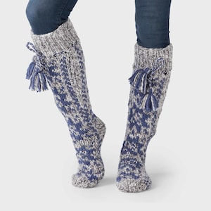May include: Knee-high knit socks in blue and gray with a patterned design. The socks have a gray cuff and are adorned with blue and gray tassels. These cozy socks are perfect for cold weather.