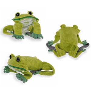 Peut inclure: Trois jouets en forme de grenouille au crochet, présentés dans différentes poses. Les grenouilles sont principalement vert clair avec des accents vert foncé sur les pieds et un intérieur blanc. Chaque grenouille a des yeux noirs et est faite de fil.