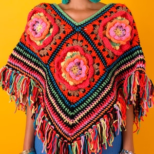 Puede incluir: Un poncho de ganchillo hecho a mano, colorido, con diseño de cuello en V. Presenta tonos vibrantes de rojo, naranja, rosa, verde y negro, con aplicaciones florales y bordes con flecos. La prenda es de estilo bohemio.