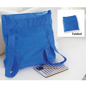 May include: A bright blue backpack with adjustable straps and a small pocket. The backpack is made of a lightweight material and is shown both open and folded. A notebook and pen are visible in the foreground.