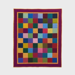May include: A colorful patchwork quilt with a vibrant array of squares in various colors, including purple, blue, green, yellow, and red. The quilt has a purple border with a gold trim, creating a striking contrast. This handmade quilt is perfect for adding a pop of color to any room.