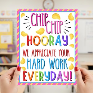 May include: A colorful classroom sign with the words "Chip Chip Hooray! We appreciate your hard work everyday!" The sign has a pink and yellow striped border and features images of potato chips.