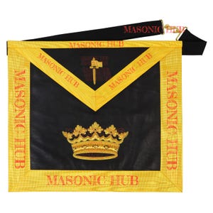 Pode incluir: Avental maçónico preto com acabamento dourado e coroa dourada bordada. O avental tem o texto "MASONIC HUB" em vermelho. Uma alça preta com o texto "MASONIC HUB" em vermelho está presa ao avental.
