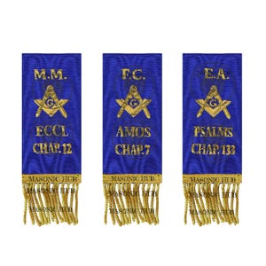 May include: Three blue Masonic ribbons with gold fringe. Each ribbon has gold text and a Masonic symbol. The text reads "M.M. ECCL CHAP. 12", "F.C. AMOS CHAP. 7", and "E.A. PSALMS CHAP. 133". The bottom of each ribbon says "MASONIC HUB".