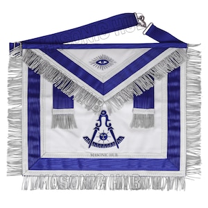 Puede incluir: Un delantal masónico blanco y azul con flecos plateados y una correa azul. El delantal presenta un símbolo de ojo, un emblema de compás y escuadra y el texto "MASONIC HUB".
