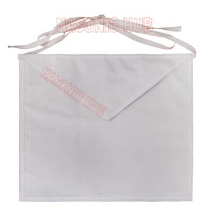 May include: A white apron with a pointed flap and a white tie. The text "MASONIC HUB" is printed in red diagonally across the apron. The apron is made of a smooth, likely cotton, fabric.