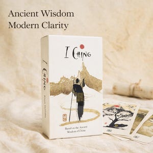May include: A white box of I Ching cards with the text "Ancient Wisdom Modern Clarity." The box features an illustration of a figure with a staff, mountains, and the text "I Ching." The cards are based on the ancient wisdom of China.