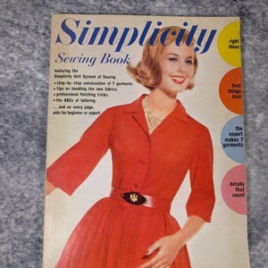 以下が含まれることがあります： 赤いドレスとベルトを身につけた人物が表紙のヴィンテージのSimplicityソーイングブック。表紙にはSimplicity Sewing Book, featuring the Simplicity Unit System of Sewing, right ideas, first things first, details that countというテキストが記載されています。