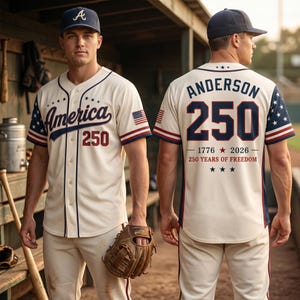 Könnte beinhalten: Ein cremefarbenes Baseballtrikot mit dunkelblauem Schriftzug America und 250 auf der Vorderseite sowie einer dunkelblauen Kappe. Auf der Rückseite stehen der Name Anderson, die Nummer 250 und der Text 1776 2026 250 YEARS OF FREEDOM mit Sternen.