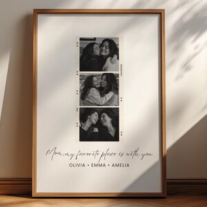 May include: A framed black and white print featuring three vertical filmstrip-style photos of two people embracing. The print includes the text "Mom, my favorite place is with you" and the names Olivia, Emma, and Amelia.