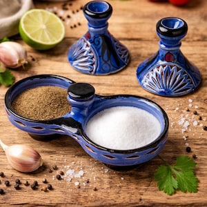 Könnte beinhalten: Ein blaues Keramik-Salz- und Pfeffer-Set mit einem passenden Paar Kerzenhaltern. Das Salz- und Pfeffer-Set ist in zwei Abschnitte unterteilt, einer mit Salz und der andere mit Pfeffer gefüllt. Die Kerzenhalter und das Salz- und Pfeffer-Set haben ein dekoratives Design.