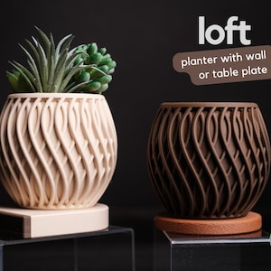 May include: Two decorative planters with a unique, woven design. One is a light beige color, and the other is brown. The planters are round and have a textured surface. The text "loft planter with wall or table plate" is visible.