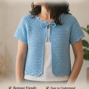 May include: A light blue, short-sleeved cardigan with a scalloped edge and tie closure. The text "Light Blue Cardigan Pattern" is at the top. The image also includes the text "Beginner Friendly", "Easy to Understand", "Step-by-Step Guide", and "Instant Digital Download".