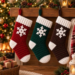 May include: Three crocheted Christmas stockings hanging in a row. The stockings are red, dark green, and dark brown, each featuring a white crocheted snowflake appliqué on the front, a white ribbed cuff, and a white toe and heel section.