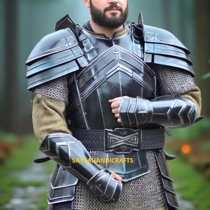 Peut inclure: Armure médiévale noire et argentée avec cotte de mailles et ceinture en cuir. L'armure comprend des épaulières, une protection de poitrine et des protège-bras. Le texte "SAYRAHANDICRAFTS" est visible.