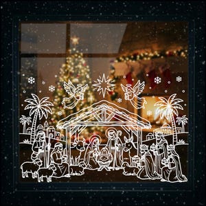 May include: White line art window cling depicting the Nativity scene. The design includes angels, a star, palm trees, and figures around a manger. The background shows a Christmas tree and lights.