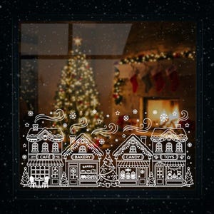 Può includere: Un adesivo bianco per finestre con una scena di villaggio natalizio. Il design include contorni dettagliati di negozi etichettati "Caffè", "Panetteria", "Caramelle" e "Giocattoli", con alberi di Natale e fiocchi di neve che cadono. Lo sfondo mostra un albero di Natale e un camino.