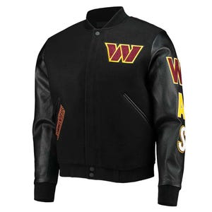 Może przedstawiać: Czarna kurtka typu varsity z bordowymi i złotymi akcentami. Posiada duże logo "W" na piersi i napisy na rękawie. Rękawy są czarne z fakturą imitującą skórę, a kurtka ma prążkowany kołnierz i mankiety.
