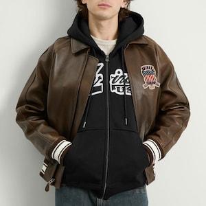 May include: A set of three ceramic mugs with a speckled, matte finish. The mugs are in shades of cream, light gray, and dark gray. Each mug has a simple, minimalist design and a rounded handle.