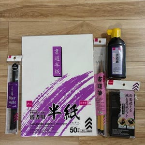 Set de caligrafía japonesa: pinceles, tinta, tintero, papel y shitajiki, ideal para principiantes.