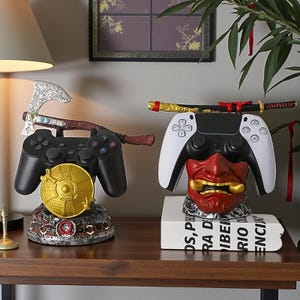 Peut inclure: Deux supports décoratifs pour manettes de jeu. L'un présente une manette noire avec une hache et un disque doré. L'autre a une manette blanche avec un masque de démon rouge et un katana. Sur une surface en bois.