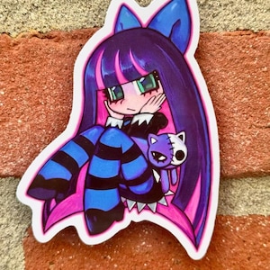 May include: A sticker depicting an anime-style character with long purple hair, a blue bow, and green eyes. The character wears a black and white outfit with blue and black striped stockings. A purple cat with a white and black face is held by the character.