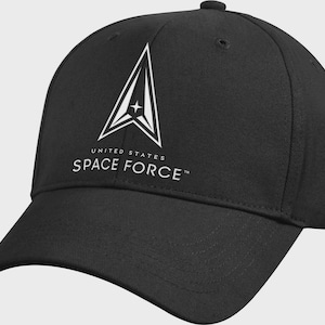 May include: Black baseball cap featuring the United States Space Force logo in white. The logo is a stylized delta shape with a star in the center. The text "UNITED STATES SPACE FORCE" is printed below the logo.