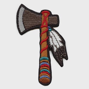 May include: A white ceramic mug with a black handle and the text "But First, Coffee" in a handwritten style. The mug is on a white surface. The mug is approximately 4 inches tall.