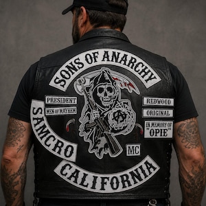 May include: Black leather vest with patches featuring the text "SONS OF ANARCHY", "SAMCRO CALIFORNIA", and a grim reaper graphic. Additional patches read "PRESIDENT", "MEN OF MAYHEM", "REDWOOD", "ORIGINAL", "IN MEMORY OF 'OPIE'", and "MC".