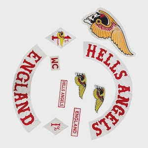 May include: A collection of embroidered patches featuring the words "ENGLAND" and "HELLS ANGELS" in red on white fabric. Other patches include a skull with wings, and the text "1%" and "MC".