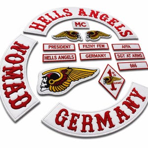 May include: A collection of embroidered patches featuring the words "Hells Angels" in red on white, along with other text like "Germany", "President", and "Filthy Few". The patches include winged skull and other motorcycle club symbols.
