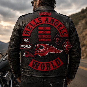 May include: A black leather motorcycle jacket featuring prominent red and black embroidered patches on the back. The patches include the text Hells Angels, Nomads, MC World, AFFA, World Chapter, 666, and 1% with a winged skull graphic design.