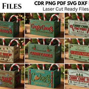 Op de afbeelding: Een collectie van negen houten vakantiekistjes met lasergesneden ontwerpen en teksten zoals Candy Cane Factory, Sweet Shop en Bake Shop. De kistjes zijn groen of beige en versierd met zuurstokken, sneeuwvlokken en feestelijke afbeeldingen.