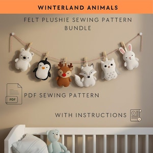 Könnte beinhalten: Ein Filz-Plüschtier-Nähpaket mit Wintertieren. Das Bild zeigt einen weißen Eisbären, Pinguin, Rentier, Fuchs, Eule und Hasen-Plüschtiere, die an einer Schnur mit Wäscheklammern hängen. Der Text oben lautet "Winterland Animals".