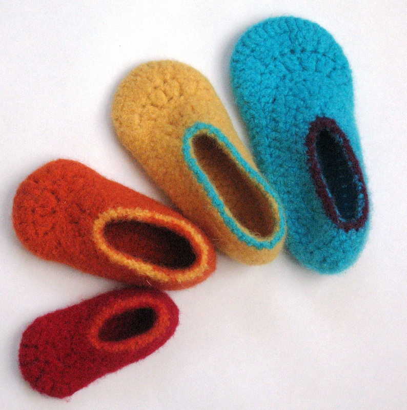 May include: Four pairs of crocheted slippers in different sizes and colors. The slippers are arranged in a semi-circle, with the largest pair at the top and the smallest pair at the bottom. The colors are blue, yellow, orange, and red.